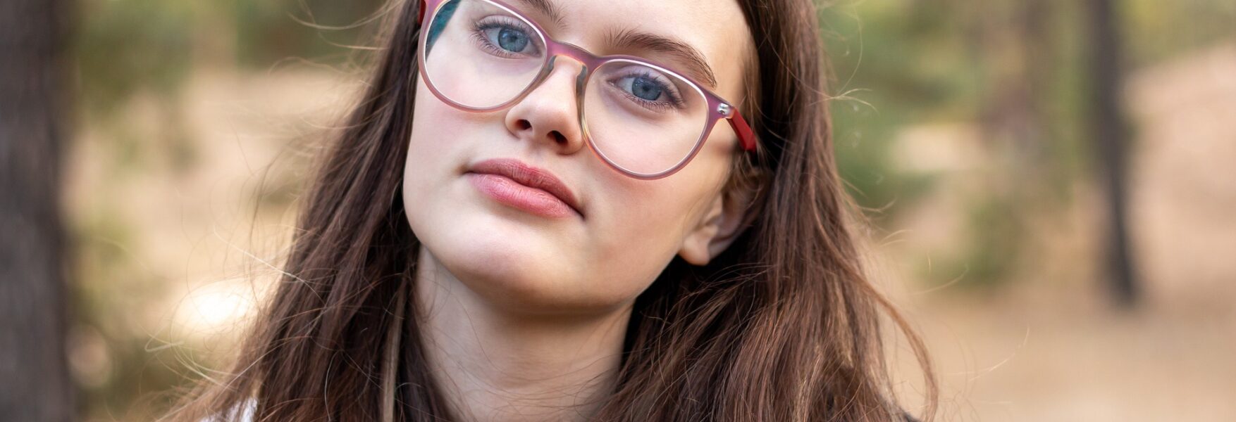 woman wearing glasses with trees behind her